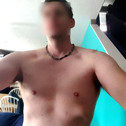 Shirtless Man in Tank Top with Necklace, Taking Selfie in House