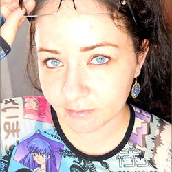 A woman in a vibrant shirt with glasses, set against a contrasting background