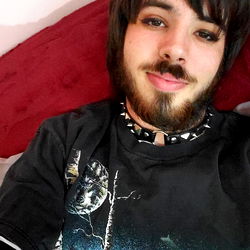 Wesley, a young man with a playful and edgy style, relaxing with his pet cat in Indianapolis.