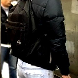 Person with backpack and headphones at train station