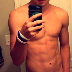 A Shirtless OnlyFans Model in a Bathroom Mirror