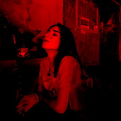 Smoking in a dimly lit setting