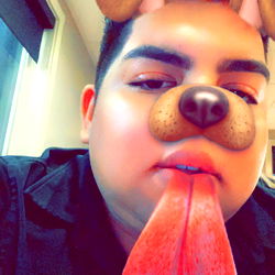 A person making a playful face behind a meme-style dog filter