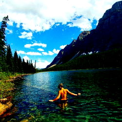 A Hiker Relaxing in a Vivid Alpine Lake