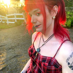 Red-haired punk rocker with ear piercings and a rebellious style,