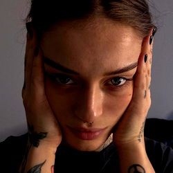 Model with striking gaze and intricate tattoo,