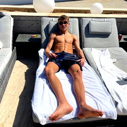 Alfie Riley, a Famous OnlyFans Model Relaxing on a Beach Chair