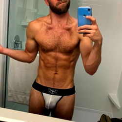 Model Showcasing Muscular Physique in Bathroom