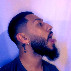 Chris, a bearded man from Texas with a tattoo and an intrigued expression.