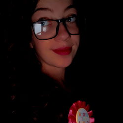 A Girl Smiling and Holding a Celebratory Item in the Photo