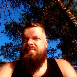 Bearded Man in Short Sleeved Shirt, Resting Backwards Against Tree