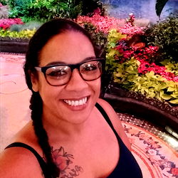 Woman in a Tank Top with Tattoos, Smiling at Camera