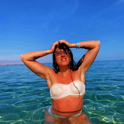 Beautiful Alex, a Ukrainian OnlyFans model, captures a moment of tranquility on the crystal blue sea shore.