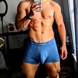 Sculpted Fitness Model Striking a Pose in a Blue Underwear Ad