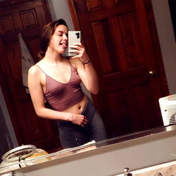 Marie, an OnlyFans model, poses confidently in front of a bathroom mirror