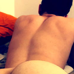 A Shirtless Young Man in a Bikini Bottom, Lying on His Stomach