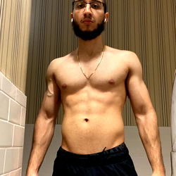 Isa, a OnlyFans model, showcasing his gym-toned body in a bathroom mirror. 26 years old. Male.