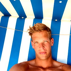 Stylish Model Relaxing by Blue Striped Umbrella