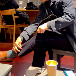 Stylish Man Enhancing His Look at a Coffee Shop