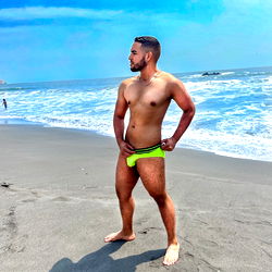 Muscular Man in Speedos on Beach