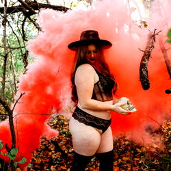 Vintage Model Poses with Red Smoke in Forest
