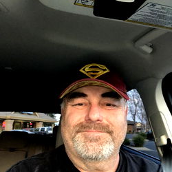 A Man Smiling at the Camera in a Car Interior