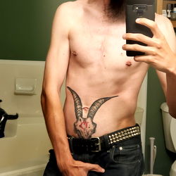 Shirtless Man with Tattoo and Piercings in Bathroom