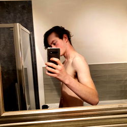 Lilly Greenshaw, Onlyfans Model, Captures a Shirtless Selfie in Bathroom Mirror