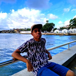 Fashionable youth poses by the water