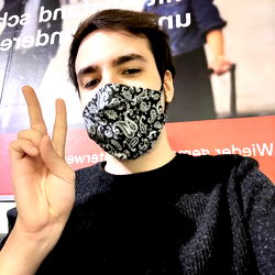 A Young Male in a Mask Making a Peace Sign