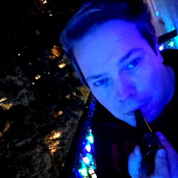 A man captured in a holiday-themed setting, seemingly lost in thought