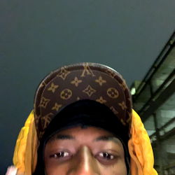 Smiling Hip-Hop Artist in Mask and Caps, Holding a Cigarette