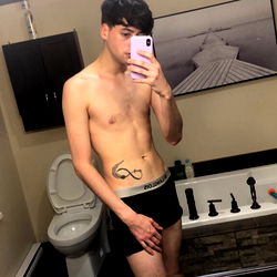 A young adult in the middle of a bathroom mirror