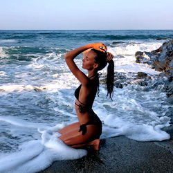Model Posing on Beach with Ocean Waves
