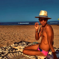 A Shirtless Model on a Beach
