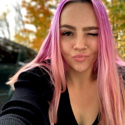 Andrea in a vibrant outdoor setting, making a playful pose for the camera.