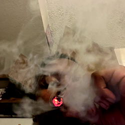 A person holding a cigarette and smoking it