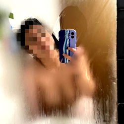 Anonymous Reflection in Bathroom Mirror