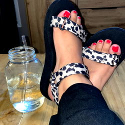 Foot in a Leopard Print Slide Sandal, Relaxing in a Home Setting