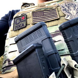 Military-Style Vest and Gun in Photograph with Text 'NKA' on Right Side