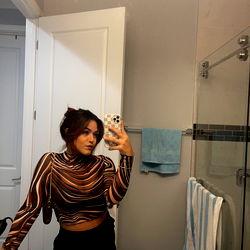 Val, an OnlyFans model posing in a bathroom mirror