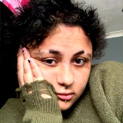 A young woman with tattoos and nose piercings.