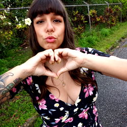 Stylish Woman in Floral Dress Making Heart Sign