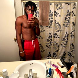 A Muscular Man in a Red Sweatshirt, Showcasing His Fitness in the Bathroom Mirror