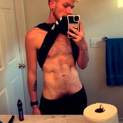 A OnlyFans Model in a Bathroom Mirror, Flaunting his Shirtless Look