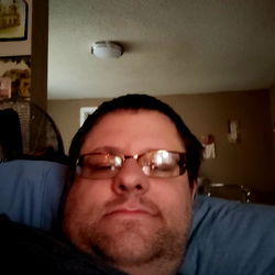 Man with glasses relaxing on bed