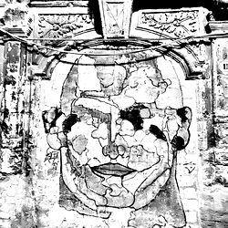 Street Art Mural with an Ancient Face on a Building Wall