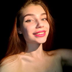 Anna Smile, a young woman with a radiant smile and a casual pose