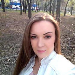 A beautiful woman posing for a selfie in a park