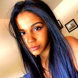 Aub, a young woman with long dark hair and striking blue eyes.